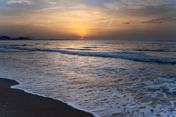 Sunrise painting the sky orange over alicante beach in spain