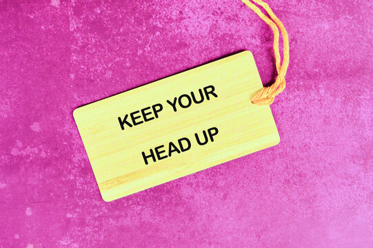 Concept words KEEP YOUR HEAD UP written on the tag on a bright abstract background