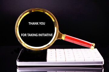 A magnifying glass with a red handle focuses on a thank you message placed above a digital...