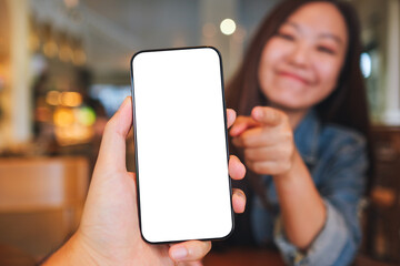 Mockup image of a man holding and a woman pointing finger at mobile phone with blank screen