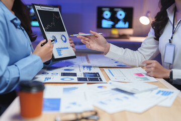 Businesswomen working with financial charts and graphs discussing project