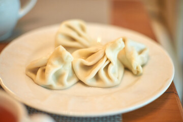 Delicious steamed dumplings on white plate ready to eat in cozy setting.