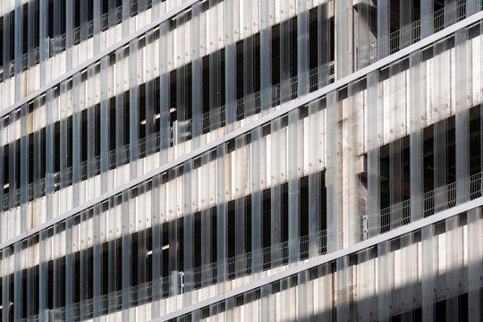 Grid-like pattern of repetitive facade elements in modern building, strong visual rhythm ideal for background or business presentation