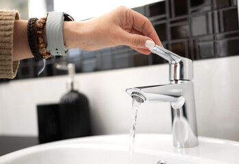 Girl Opens The Mixer Tap Of The Sink In The Bathroom