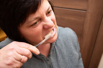 Brushing teeth in a cozy bathroom while expressing determination to maintain oral hygiene in a warm...