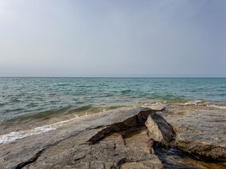 Rocky shore and clear water of Issyk-Kul under a vast sky