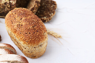 Freshly baked loaves of bread on light table, closeup. Space for text