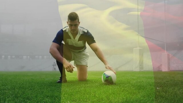 Rugby player kneeling adjusting cleat placing ball on tee for goal kick while camera following