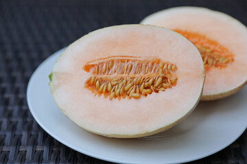 Halves of juicy melon on wicker table, closeup