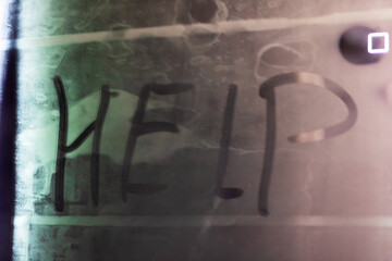 The word help is prominently spray painted on a nearby wall