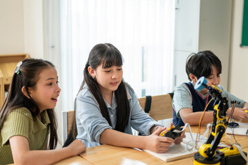 Fototapeta premium Group of students learning in a robotics class at elementary school. 