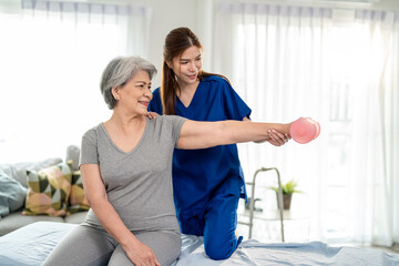 Asian senior mature woman doing physiotherapist with support from nurse.