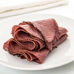 Folded roast beef deli meat slices on a plate