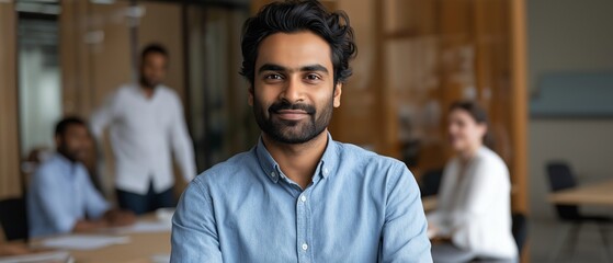 Indian startup looks at the camera with a smile. At a business meeting, the businessman exudes confidence.