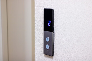 A sleek black elevator button featuring the number 2 prominently on it