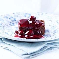 Chocolate brownie with cherry syrup . Selective focus. Copy space.	