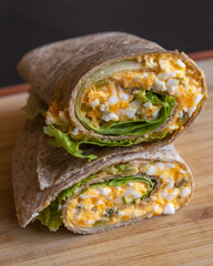 Devil egg wraps healthy breakfast on wooden cutting board. Close-up photo of a fresh, light meal...