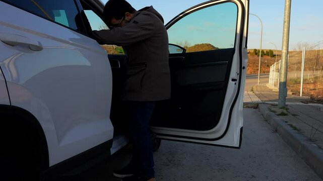 Grandson helping his grandma get in the car and fasten seat belt