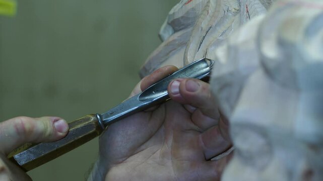Extreme macro close up of Skilled craftsman hamd meticulously carving detailed wooden sculpture, showcasing traditional chisel technique with precise hand movements and expert woodworking precision