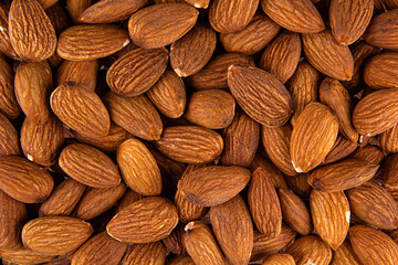 Background of big raw peeled almonds situated arbitrarily, background peeled almond