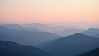 Obraz premium Layered mountain range silhouette during a pink and orange sunset.
