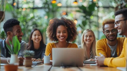 Diverse group of young adults looking at laptop together in cafe. Students collaborate on project, sharing ideas and working as team. Happy colleagues brainstorming during coffee break. - Powered by Adobe