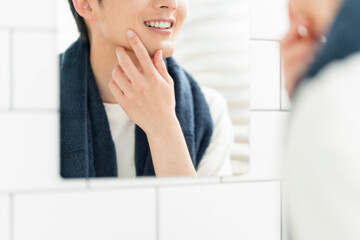自宅の洗面所で身だしなみを整える若い日本人男性