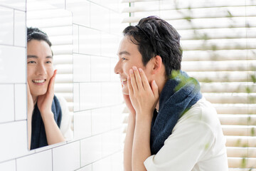 洗面所で洗顔をしている若い日本人男性