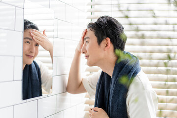 自宅の洗面所で身だしなみを整える若い日本人男性