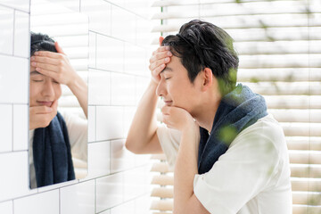 自宅の洗面所で身だしなみを整える若い日本人男性