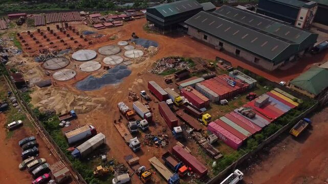 Jib down of a large industrial zone with factories and a building under construction Ibadan, Nigeria on a sunny day