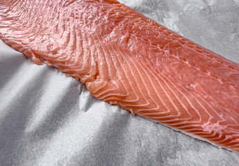 Raw salmon fillet ready for baking, fresh seafood prepared for healthy cooking, concept of nutritious marine food and culinary preparation