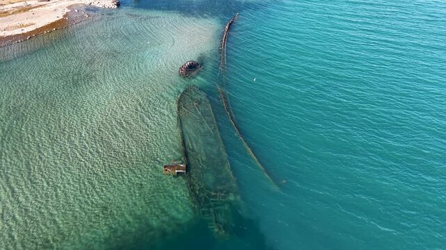 Aerial drone shot of a visible shipwreck off the coast of Detour Village, Michigan in clear blue waters of Lake Huron