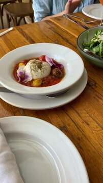 Point of view from phone filming italian restaurant dishes served for dinner or lunch on table. Food vlogger enjoying colorful plates with fancy quality food from italy. Healthy salads and fun drinks