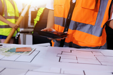 Closeup of team of industrial engineers meeting analyze machinery blueprints consult project on table in manufacturing factory. Working in manufacturing plant or production plant.