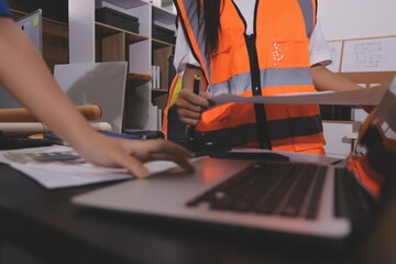 Closeup of team of industrial engineers meeting analyze machinery blueprints consult project on table in manufacturing factory. Working in manufacturing plant or production plant.