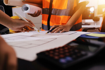 Closeup of team of industrial engineers meeting analyze machinery blueprints consult project on table in manufacturing factory. Working in manufacturing plant or production plant.