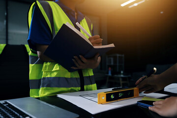 Closeup of team of industrial engineers meeting analyze machinery blueprints consult project on table in manufacturing factory. Working in manufacturing plant or production plant.