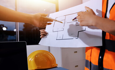 Closeup of team of industrial engineers meeting analyze machinery blueprints consult project on table in manufacturing factory. Working in manufacturing plant or production plant.