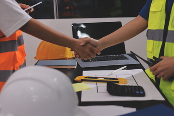 Closeup of team of industrial engineers meeting analyze machinery blueprints consult project on table in manufacturing factory. Working in manufacturing plant or production plant.