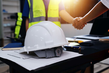 Closeup of team of industrial engineers meeting analyze machinery blueprints consult project on table in manufacturing factory. Working in manufacturing plant or production plant.