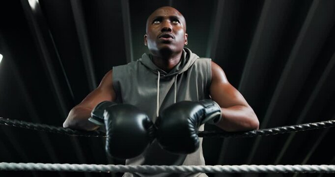 Sport, boxer and tired black man on rope for rest, sweat and ready for challenge. Athlete, boxing ring and break in gym with breathing, fatigue and motivation for fight or fitness with low angle