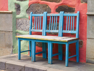 Blaue Stühle vor einer bunten Hauswand