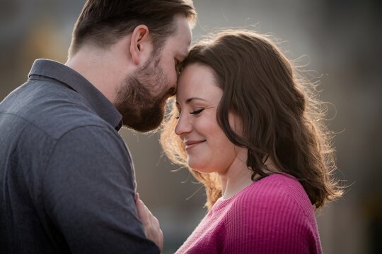 A happy couple sharing an intimate moment, showcasing love and connection in warm golden light.