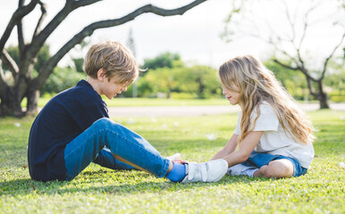 Fototapeta premium Brother and sister playing together at the park in the morning sunrise