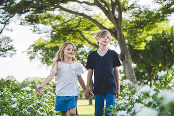 Fototapeta premium Brother and sister playing together at the park in the morning sunrise
