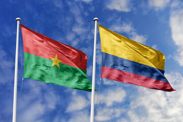 A Burkina Faso and Colombia flag, a metaphor for South American-African ties, wave together against a blue sky, symbolizing friendship and cultural exchange.