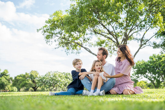 Happy family parent children having picnic outdoor activity. Enjoy happiness moment summer playing together including father mother son and daughter relaxing in the morning sunrise.