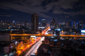 Bangkok city skyline at night with light trails on expressway, long exposure urban view in Thailand
