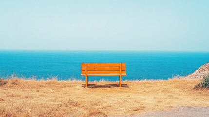 Solitary orange wooden bench overlooking a calm, expansive blue ocean from a dry, grassy clifftop under a clear, pale sky